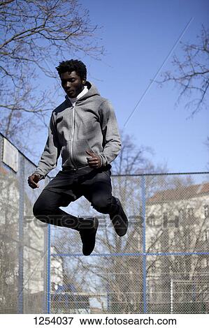 A serious young man jumping high in the air, Berlin, Germany View Large Photo Image Stock Photo - A serious young man jumping high in the air, Berlin, Germany. Fotosearch