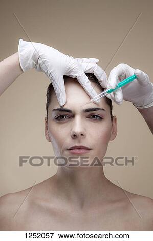 A serious young woman receiving Botox injections View Large Photo Image Stock Photo - A serious young woman receiving Botox injections. Fotosearch