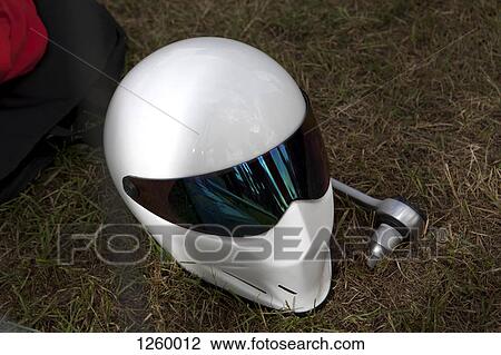 A sleek modern crash helmet lying on grass next to socket wrench View Large Photo Image Stock Image - A sleek modern crash helmet lying on grass next to socket wrench. Fotosearch