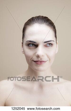 A smiling young woman looking to the side mischievously View Large Photo Image Stock Photography - A smiling young woman looking to the side mischievously. Fotosearch
