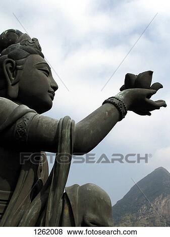 Stock Photo - A statue offering a lotus flower to the Big Buddha, Lantau Island, Hong Kong. Fotosearch