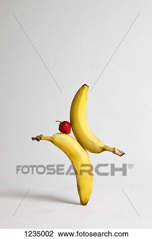 A strawberry balancing between two bananas View Large Photo Image Stock Image - A strawberry balancing between two bananas. Fotosearch