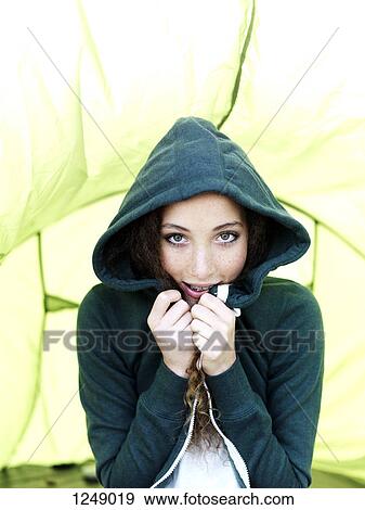 A teenage girl sitting in a tent pulling the sides of her hood sweatshirt together View Large Photo Image Stock Photo - A teenage girl sitting in a tent pulling the sides of her hood sweatshirt together. Fotosearch