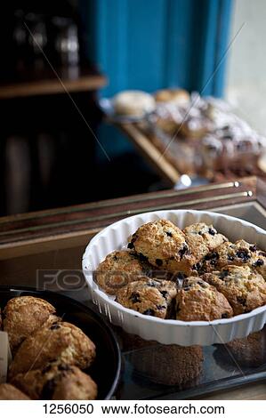 Stock Image - A variety of scones for sale on display in a coffee shop. Fotosearch