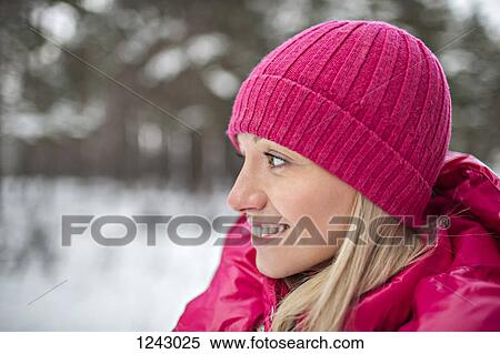 Stock Photography - A woman wearing bright pink winter clothing outdoors. Fotosearch