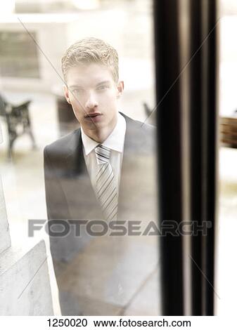 A young businessman arriving to a building, seen through window View Large Photo Image Stock Image - A young businessman arriving to a building, seen through window. Fotosearch