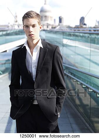 A young businessman posing with his hands in his pockets View Large Photo Image Stock Image - A young businessman posing with his hands in his pockets. Fotosearch