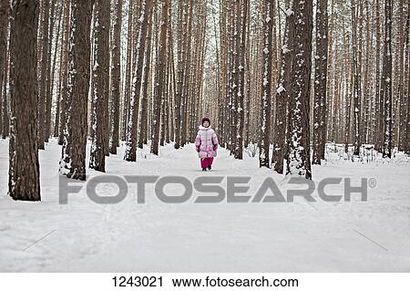 A young girl walking down a snow packed path in the forest View Large Photo Image Stock Image - A young girl walking down a snow packed path in the forest. Fotosearch