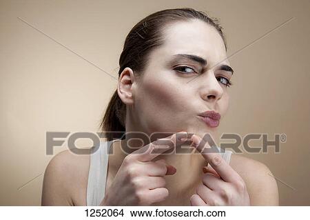 A young woman concentrating as she squeezes a pimple View Large Photo Image Picture - A young woman concentrating as she squeezes a pimple. Fotosearch