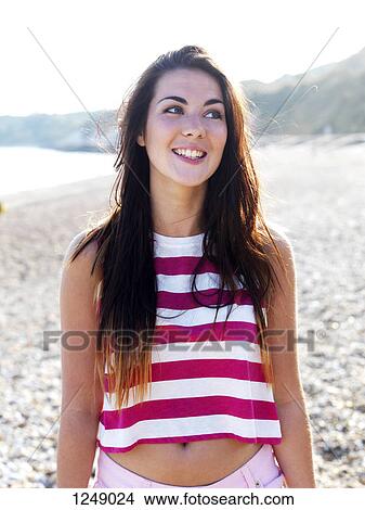 A young woman smiling cheerfully while looking away View Large Photo Image Picture - A young woman smiling cheerfully while looking away. Fotosearch