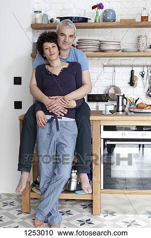 An affectionate smiling mixed age couple in their kitchen View Large Photo Image Stock Image - An affectionate smiling mixed age couple in their kitchen. Fotosearch