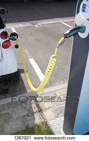 An electric car recharging at a charging station View Large Photo Image Stock Image - An electric car recharging at a charging station. Fotosearch