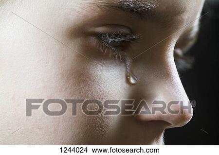 Picture - Close-up of a girl shedding a tear. Fotosearch