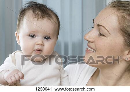 Stock Image - Daughter in her mother's arms. Fotosearch