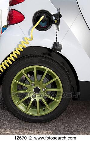 Detail of a charger connected to an electric car recharging View Large Photo Image Stock Image - Detail of a charger connected to an electric car recharging. Fotosearch