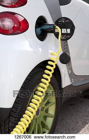 Detail of a charger connected to an electric car recharging View Large Photo Image Stock Photograph - Detail of a charger connected to an electric car recharging. Fotosearch