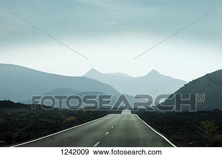 Empty road leading towards mountains in Lanzarote, Canary Islands, Spain View Large Photo Image Stock Photo - Empty road leading towards mountains in Lanzarote, Canary Islands, Spain. Fotosearch