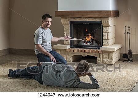 Father and son relaxing next to fire View Large Photo Image Stock Photo - Father and son relaxing next to fire. Fotosearch
