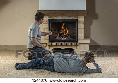 Father and son relaxing next to fire View Large Photo Image Stock Photograph - Father and son relaxing next to fire. Fotosearch