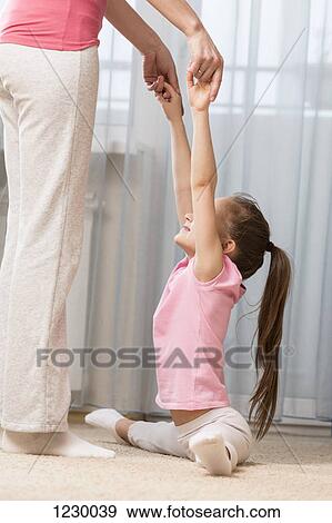 Girl doing the splits with a little help from her mother View Large Photo Image Stock Photo - Girl doing the splits with a little help from her mother. Fotosearch