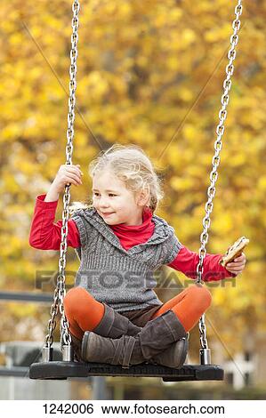 Girl on swing holding sandwich View Large Photo Image Stock Photograph - Girl on swing holding sandwich. Fotosearch