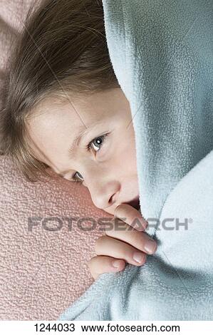 Stock Image - Girl under blanket. Fotosearch