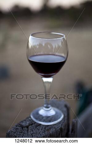Glass of red wine perched on wood in Heathcote, Victoria, Australia View Large Photo Image Stock Image - Glass of red wine perched on wood in Heathcote, Victoria, Australia. Fotosearch