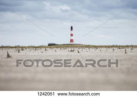 Jagged shapes of sand on beach with lighthouse in background, Schleswig Holstein, Germany, View Large Photo Image Stock Image - Jagged shapes of sand on beach with lighthouse in background, Schleswig Holstein, Germany,. Fotosearch