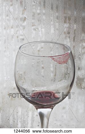 Lipstick on a glass of red wine with rain covered window in the background View Large Photo Image Stock Photograph - Lipstick on a glass of red wine with rain covered window in the background. Fotosearch
