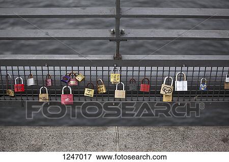 Love padlocks hanging in a row on a bridge railing in Berlin, Germany View Large Photo Image Stock Photo - Love padlocks hanging in a row on a bridge railing in Berlin, Germany. Fotosearch
