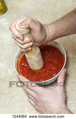 Man using wooden pestle to mix tomato sauce View Large Photo Image Picture - Man using wooden pestle to mix tomato sauce. Fotosearch