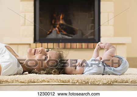 Mother and daughter lying head to head on carpet in front of fire View Large Photo Image Stock Image - Mother and daughter lying head to head on carpet in front of fire. Fotosearch