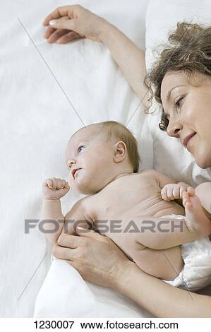 Stock Photo - Mother and daughter on bed. Fotosearch