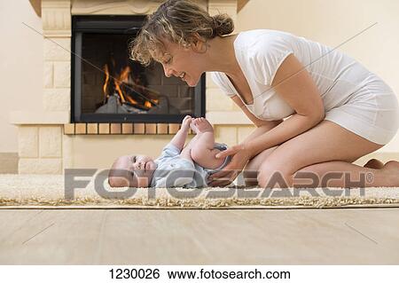 Stock Photograph - Mother and daughter on carpet in front of the fire. Fotosearch