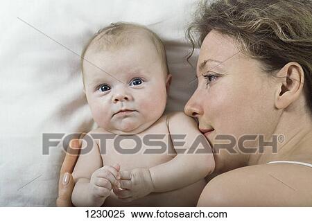 Stock Photography - Mother and daughter relaxing on bed. Fotosearch