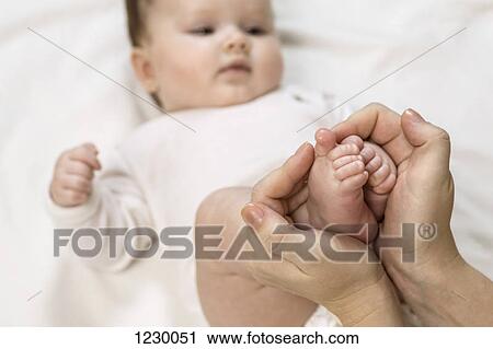 Stock Image - Mother holding child's feet. Fotosearch