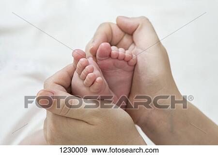 Stock Photo - Mother holding daughter's feet. Fotosearch