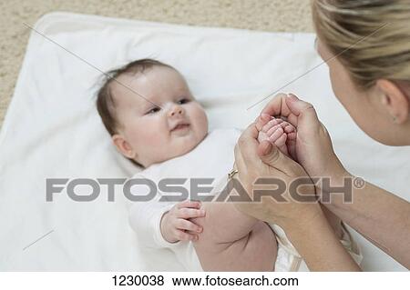 Stock Photo - Mother holding her daughter's feet . Fotosearch