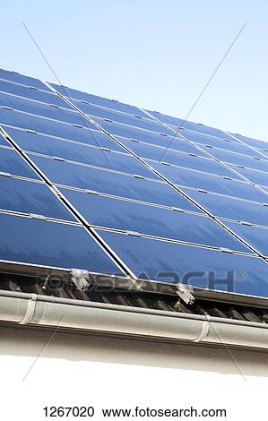 Stock Image - Rows of solar panels, low angle view, close-up. Fotosearch