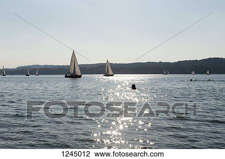 Silhouetted swimmers and sailboats in lake at Starnberger Sea, Bavaria, Germany View Large Photo Image Stock Image - Silhouetted swimmers and sailboats in lake at Starnberger Sea, Bavaria, Germany. Fotosearch