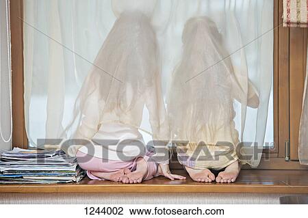 Sisters on window sill looking out window View Large Photo Image Stock Image - Sisters on window sill looking out window. Fotosearch