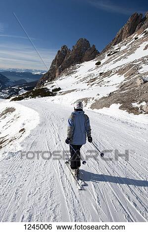 Stock Photograph - Skier with view of snow-capped mountains of The Dolomites, South Tyrol, Italy,. Fotosearch