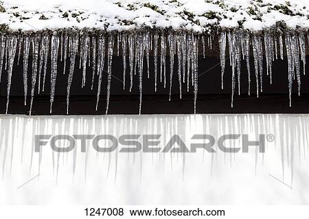 Snow and a row of icicles hanging from the eaves of a building View Large Photo Image Stock Photo - Snow and a row of icicles hanging from the eaves of a building. Fotosearch