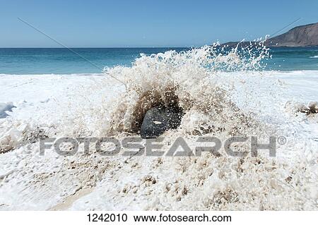 Splash of wave against rock on beach in La Graciosa, Canary Islands, Spain View Large Photo Image Stock Image - Splash of wave against rock on beach in La Graciosa, Canary Islands, Spain. Fotosearch