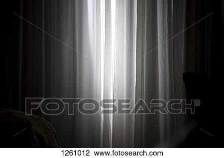 Sunlight coming in through slightly parted curtains in a bedroom View Large Photo Image Stock Image - Sunlight coming in through slightly parted curtains in a bedroom. Fotosearch