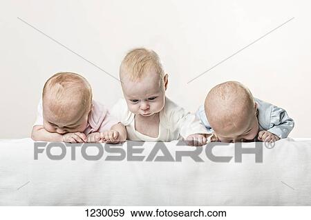 Three babies in a row pulling funny faces View Large Photo Image Stock Photo - Three babies in a row pulling funny faces. Fotosearch