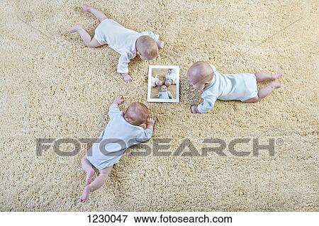 Three babies look at a picture of themselves on a digital tablet View Large Photo Image Stock Photo - Three babies look at a picture of themselves on a digital tablet. Fotosearch