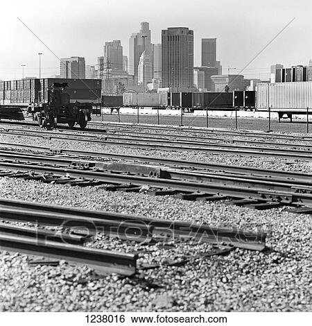 Stock Photograph - Train tracks, cargo containers and skyscrapers in Los Angeles, California, USA. Fotosearch