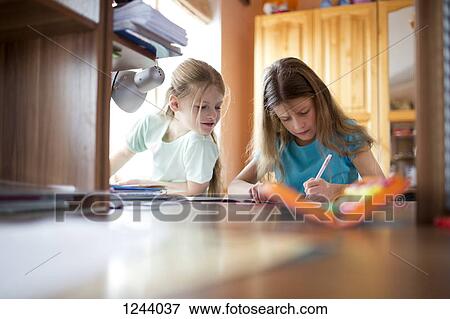 Stock Photo - Two sisters doing homework. Fotosearch