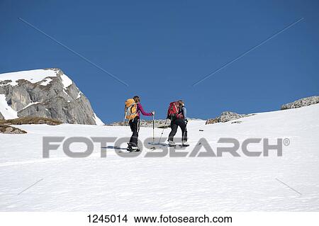 Two skiers moving up a snowy hill on The Dolomites, South Tyrol, Italy, View Large Photo Image Picture - Two skiers moving up a snowy hill on The Dolomites, South Tyrol, Italy,. Fotosearch